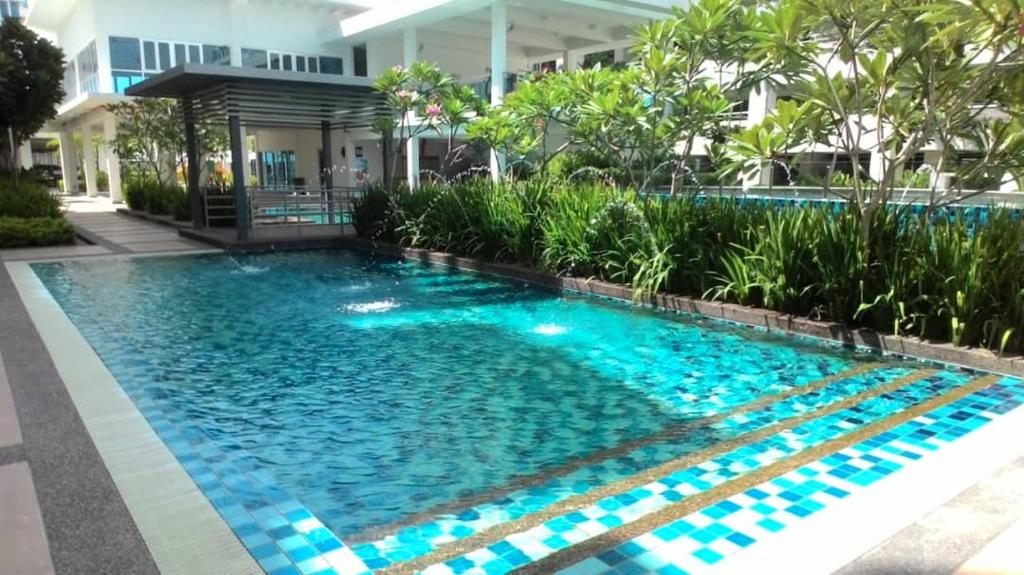 una piscina al centro di un edificio con acqua blu di Homestay de Putra a Kajang