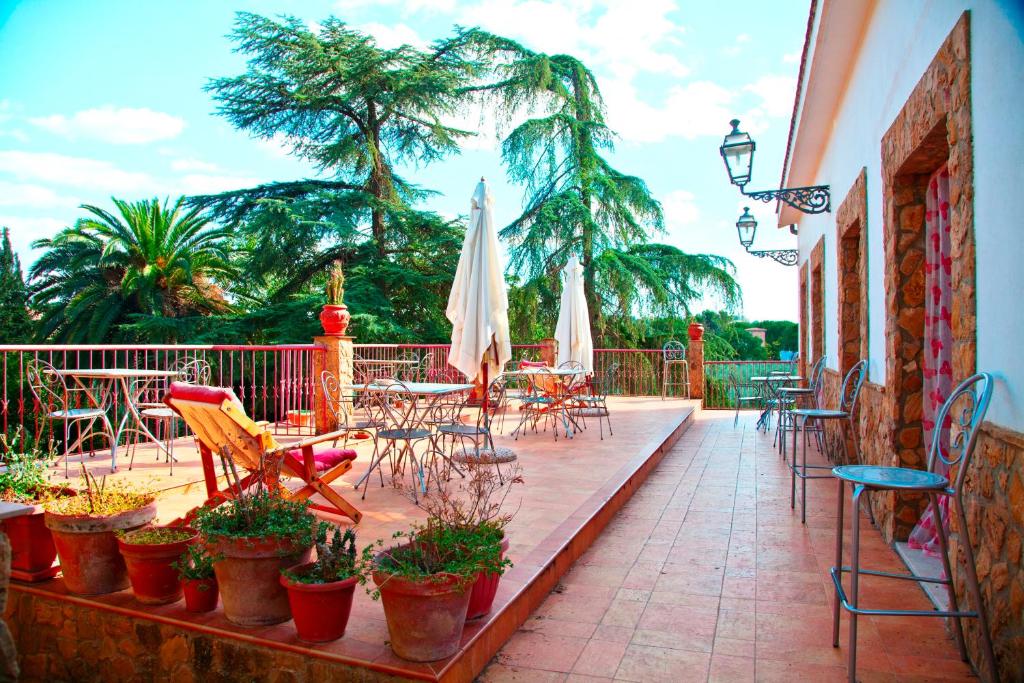 d'une terrasse avec des tables, des chaises et un parasol. dans l'établissement B&B Villa Casablanca, à Enna