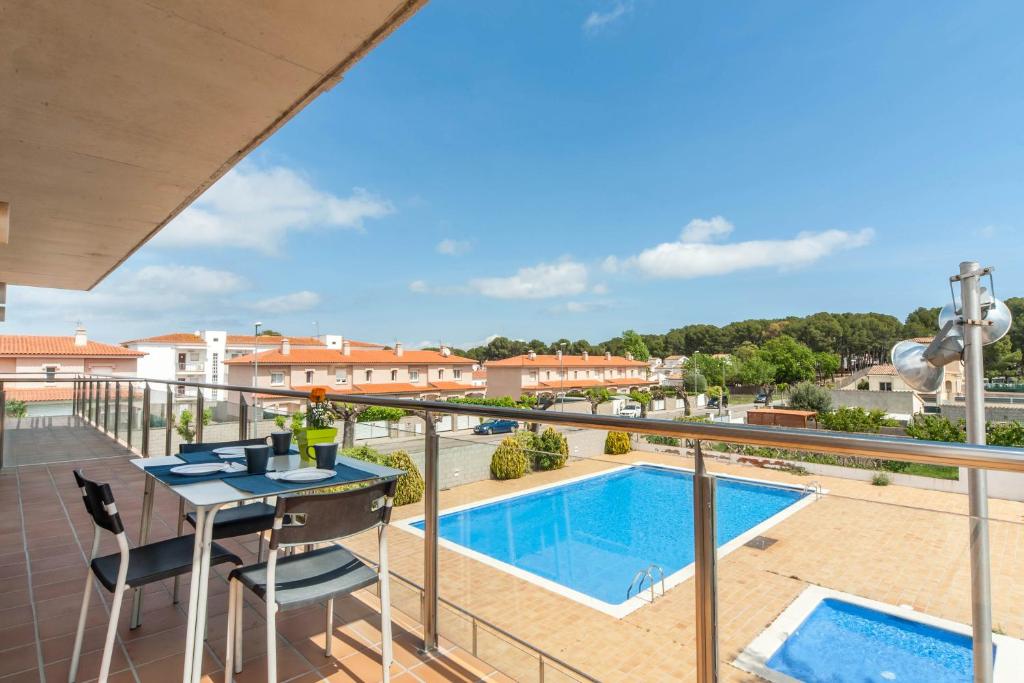 balcón con mesa y sillas y piscina en Salseta en L'Escala