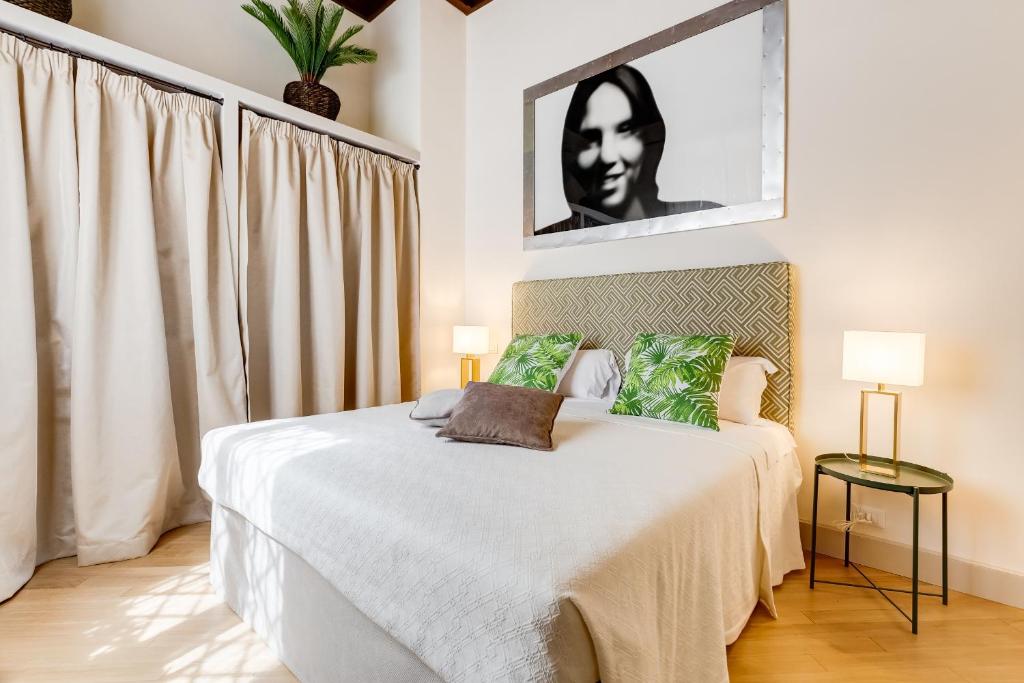 una camera da letto con un letto con un dipinto bianco e nero sul muro di Trevi Chic House a Roma