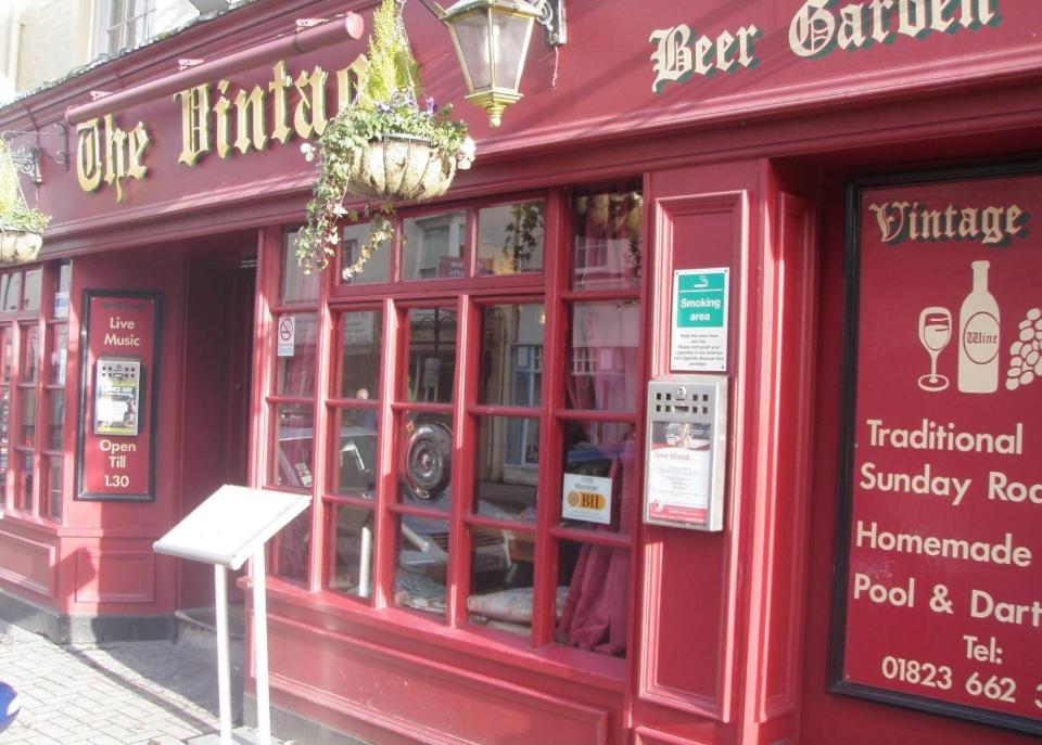 um restaurante vermelho com uma placa em frente em The Vintage Inn em Wellington