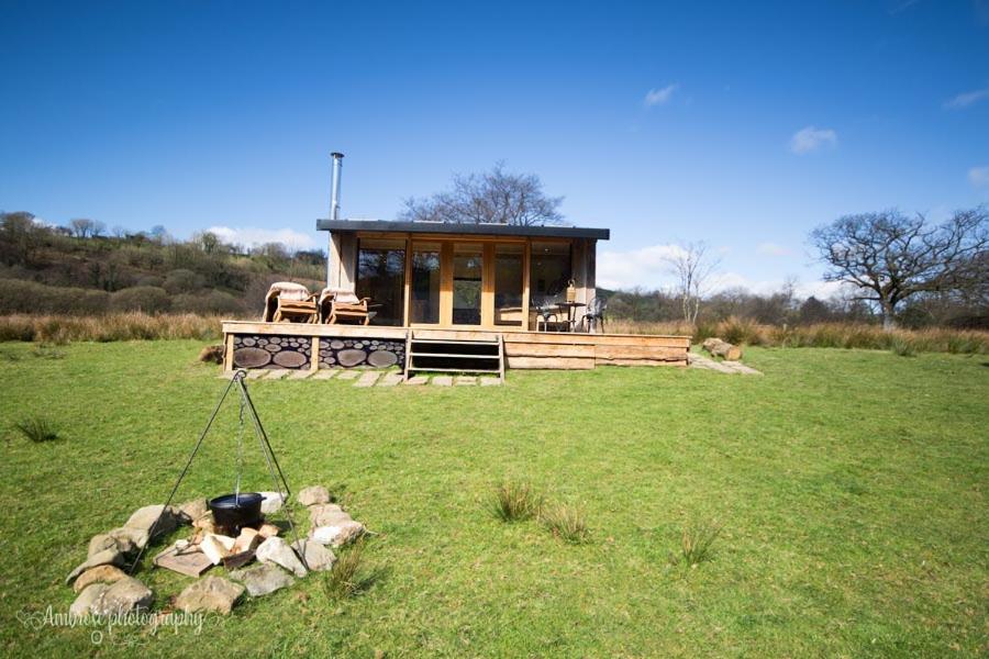 a small house in the middle of a field at Serenity Lodge in Llandeilo