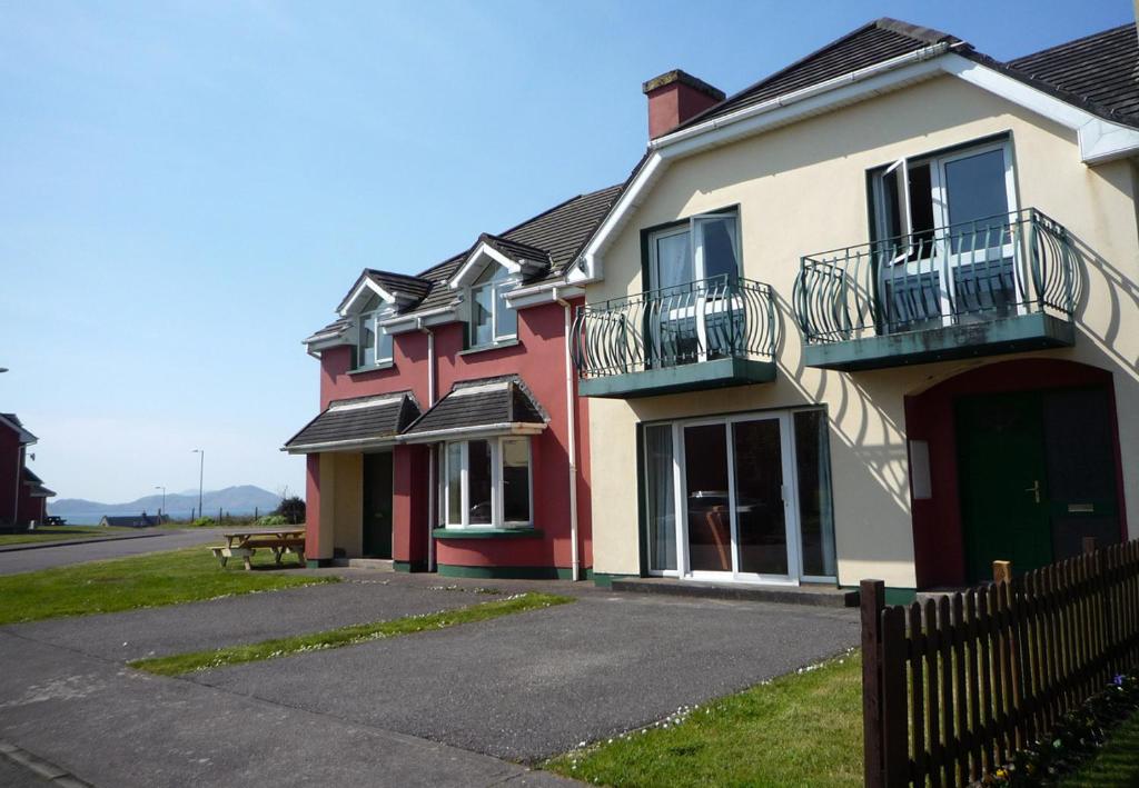 een rood-wit huis met een hek bij The Links Waterville No 8 in Waterville