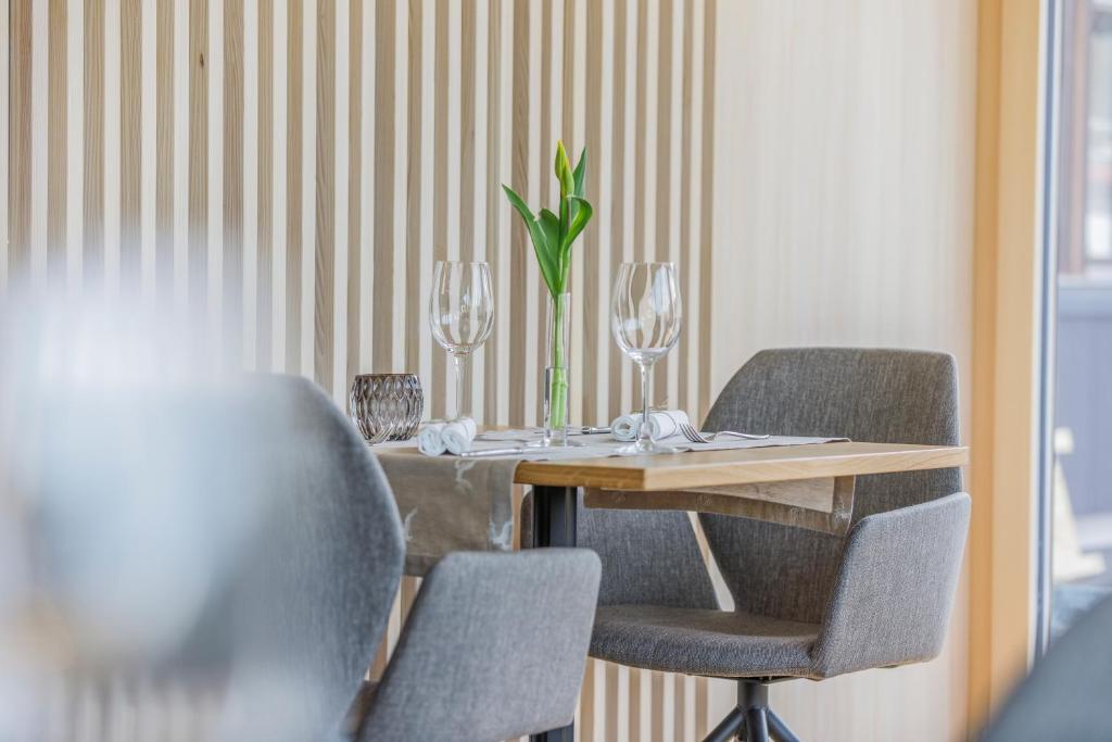 une table avec deux chaises et un vase avec une plante dans l'établissement Hotel Daneu, à Nüziders