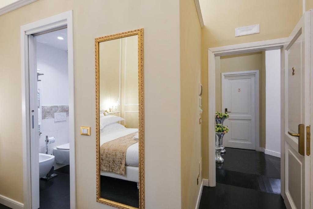 a mirror in a room with a bed and a bathroom at B&B Kingsman in Florence