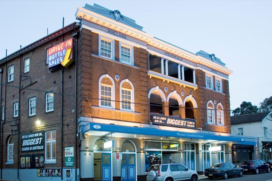 a brick building with cars parked in front of it at Strathfield Hotel in Sydney