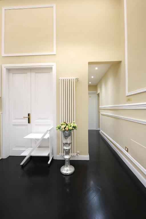 a room with a vase of flowers on a black floor at B&B Kingsman in Florence