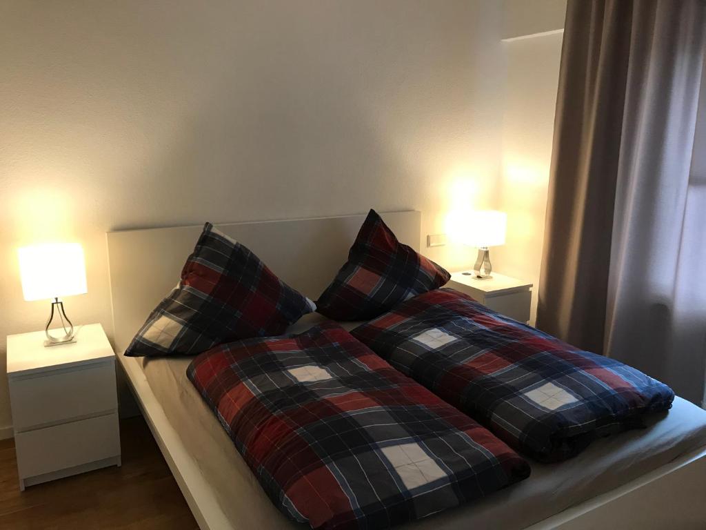 a bed with two pillows on it with two lamps at Ludwig 6 in Oberhausen