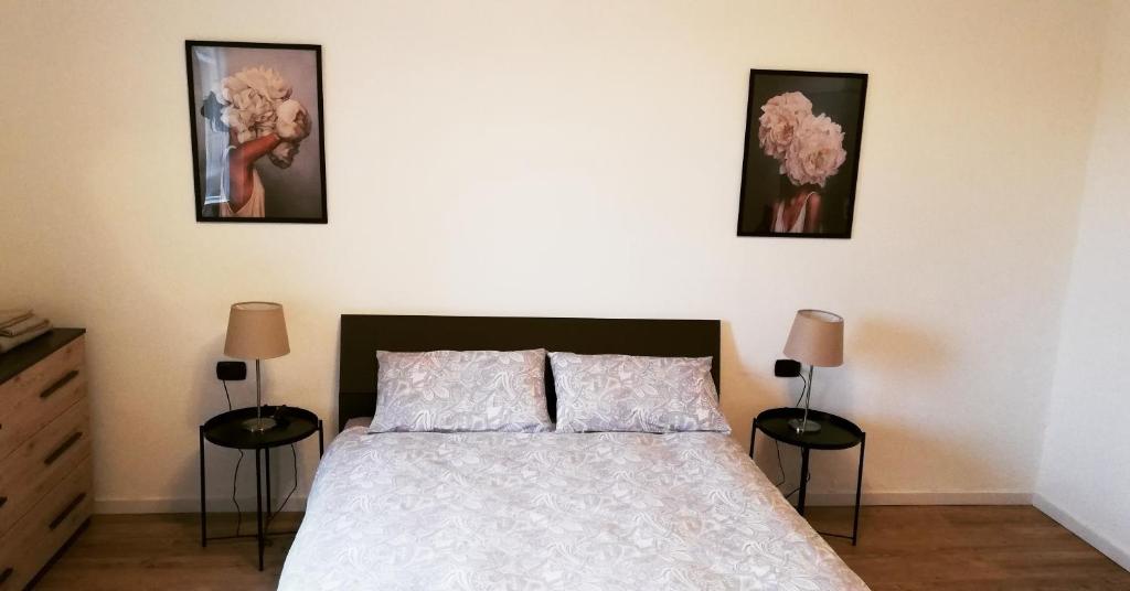 a bedroom with a bed and three pictures on the wall at CENTRO e PARCO 10 min - flat in Monza in Monza