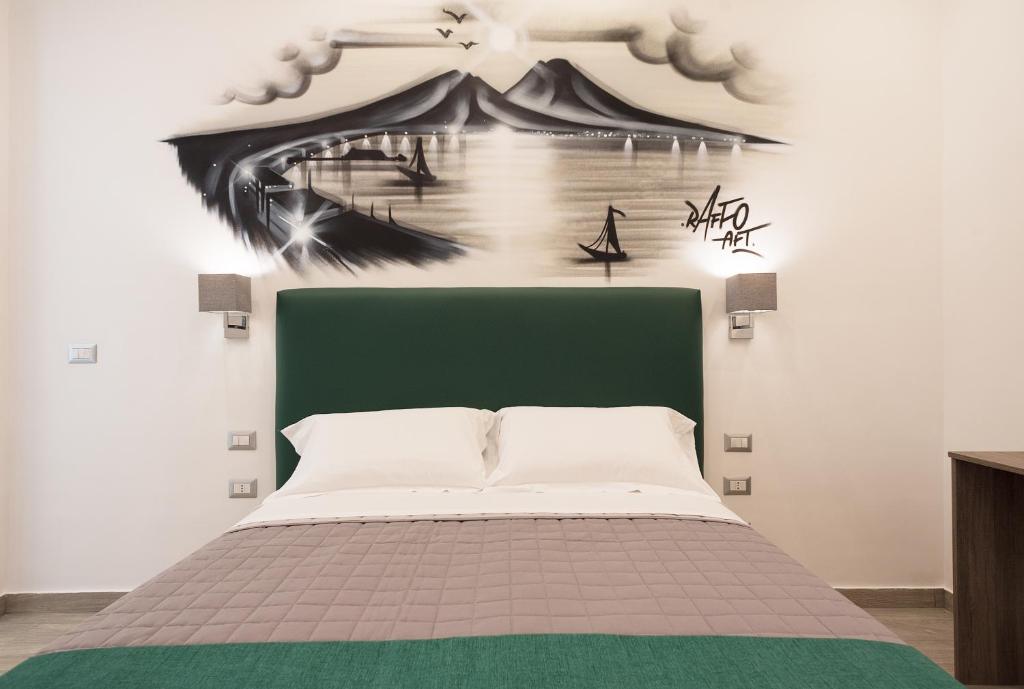 B&B Toledo one في نابولي: غرفة نوم مع سرير وطاولة خضراء للرأس