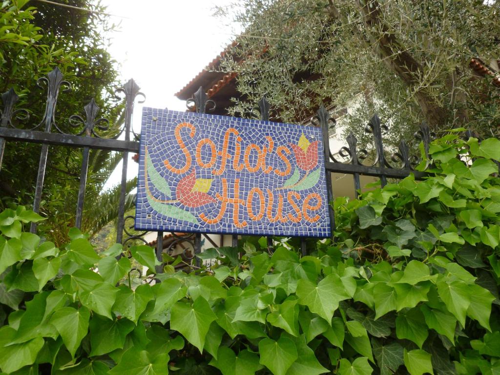 a sign on a fence with a garden at Sofia's House in Paleo Tsifliki