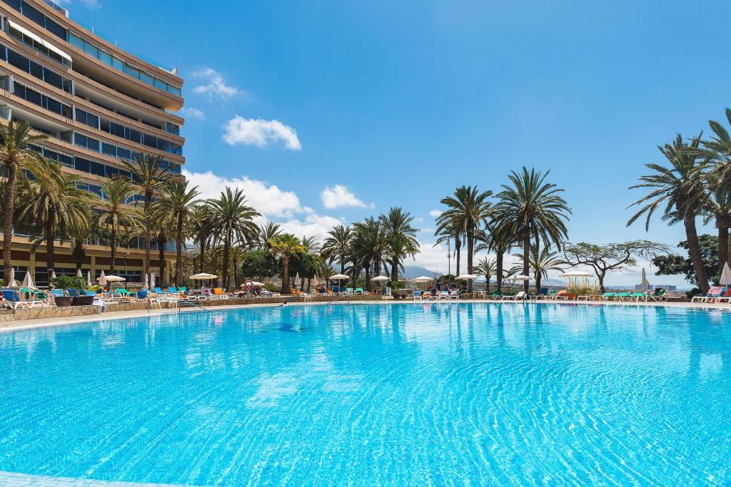 a large swimming pool with palm trees and a hotel at MARAZUL VISTA AL MAR in Callao Salvaje