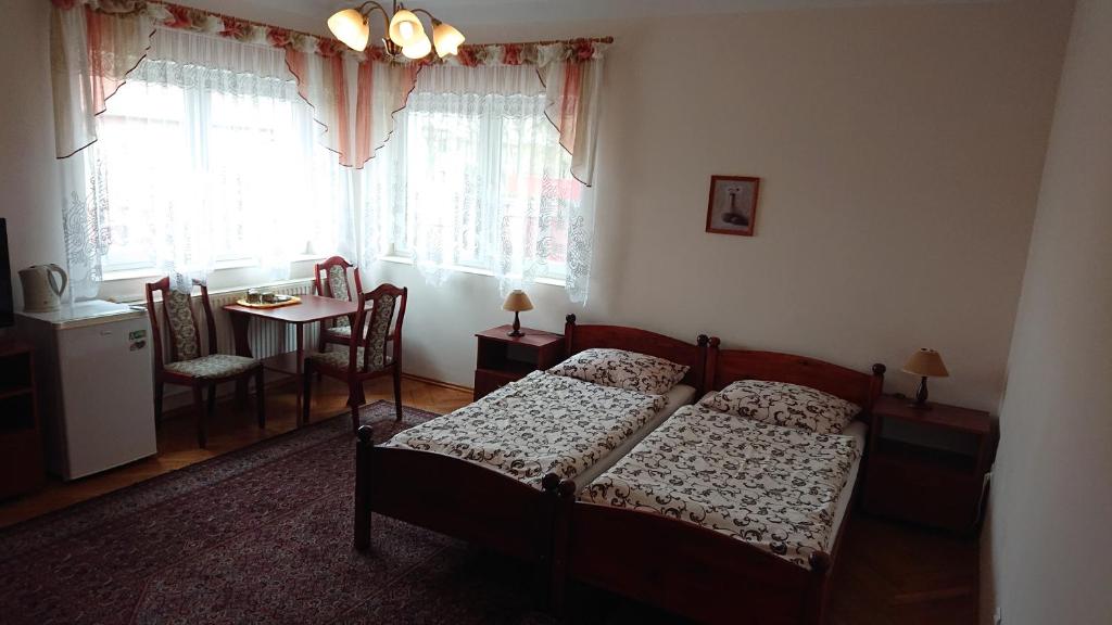 um quarto com uma cama, uma mesa e uma janela em Apartamenty i Pokoje Willa Dafne em Ciechocinek