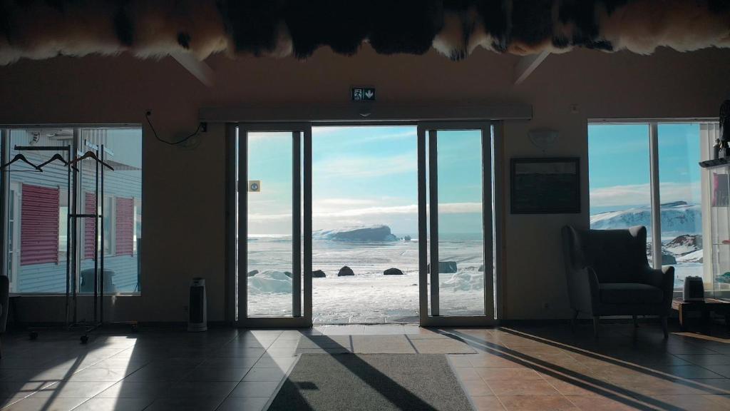 a room with sliding glass doors with a view of the ocean at Hótel Dyrhólaey in Vík