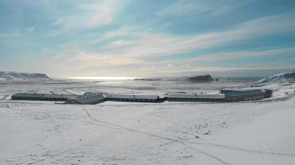 a group of buildings sitting on a snow covered beach at Hótel Dyrhólaey in Vík