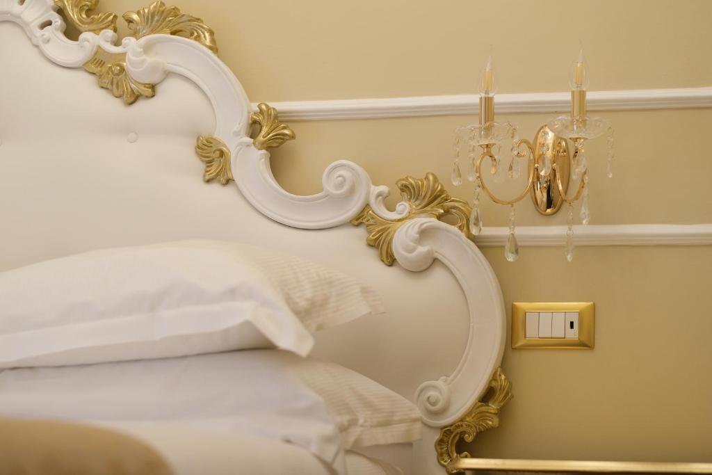 a bedroom with a white bed with a gold frame at B&B Kingsman in Florence