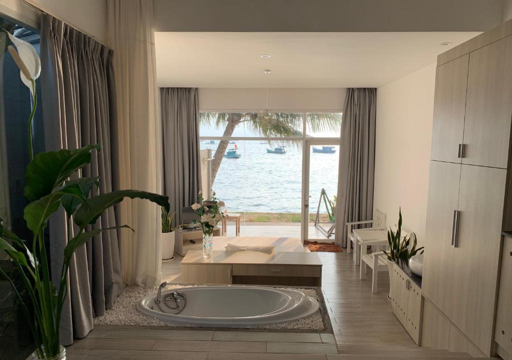 - une baignoire dans une chambre avec vue sur l'eau dans l'établissement HS Beach House Phu Quoc Island, à Duong Dong