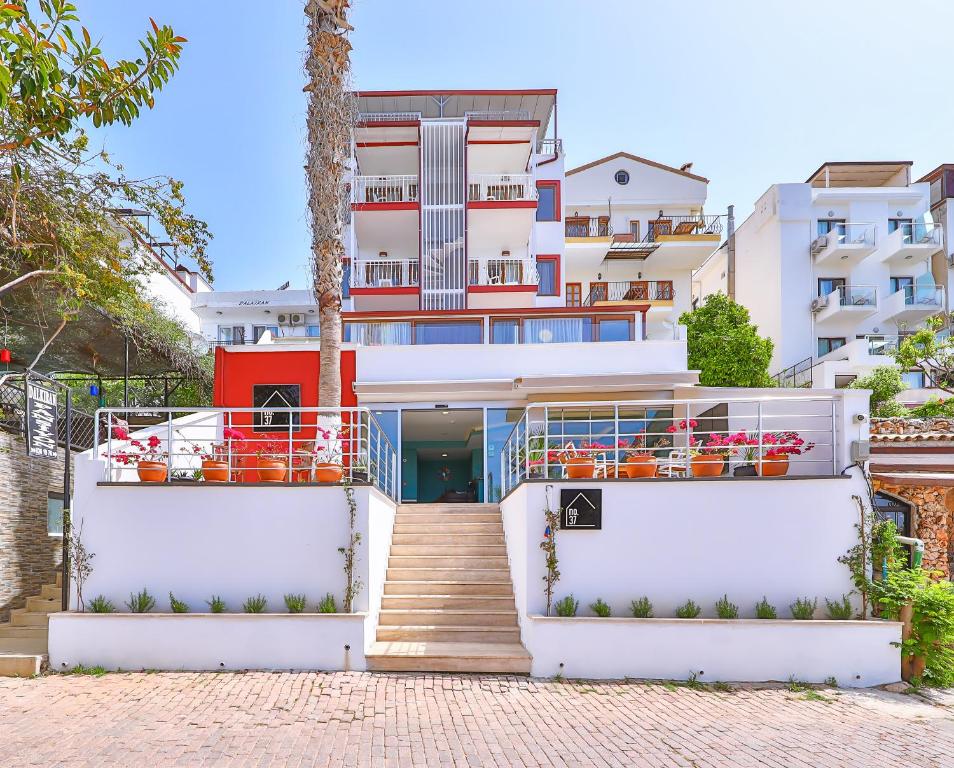 a large white building with stairs and orange chairs at Hotel No37 in Kas