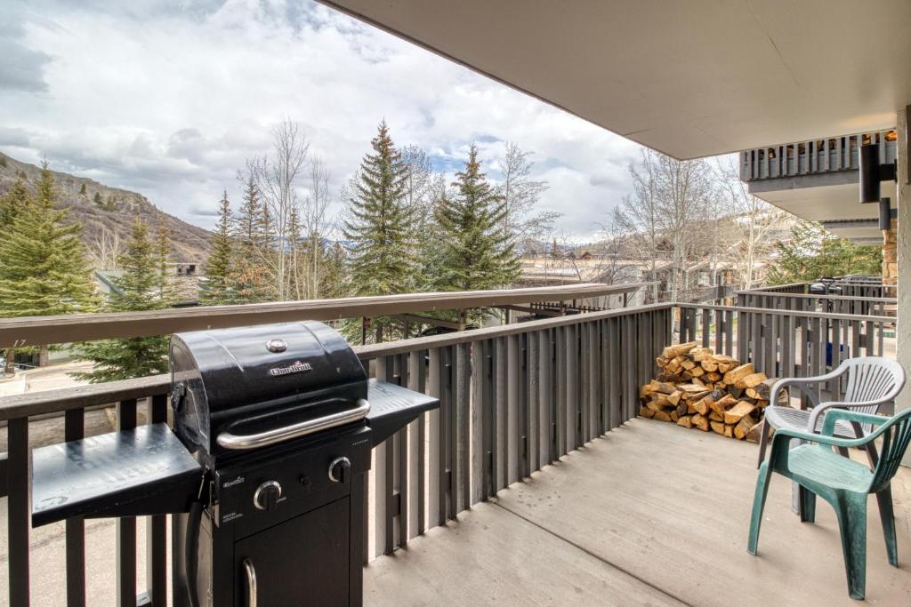 a grill on a deck with a table and chairs at 1 Bath Studio Apartment in Snowmass Village in Snowmass Village