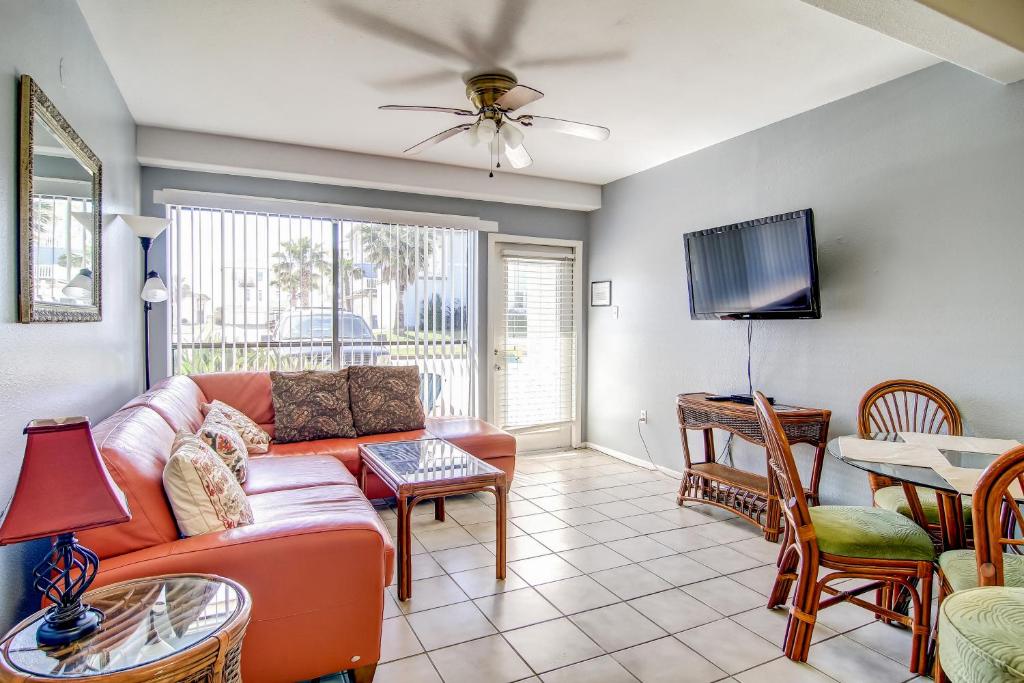 a living room with a couch and a tv at Sand & Surf Sea Mist Condos in Port Aransas