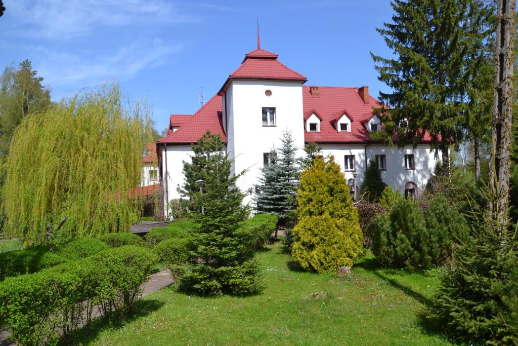 ein großes weißes Haus mit rotem Dach in der Unterkunft Jodełka in Święta Katarzyna