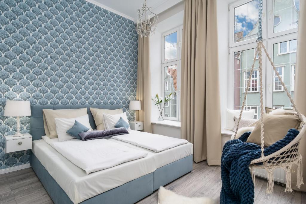a bedroom with a swinging bed and a blue wall at Elite Apartments Piwna Premium in Gdańsk