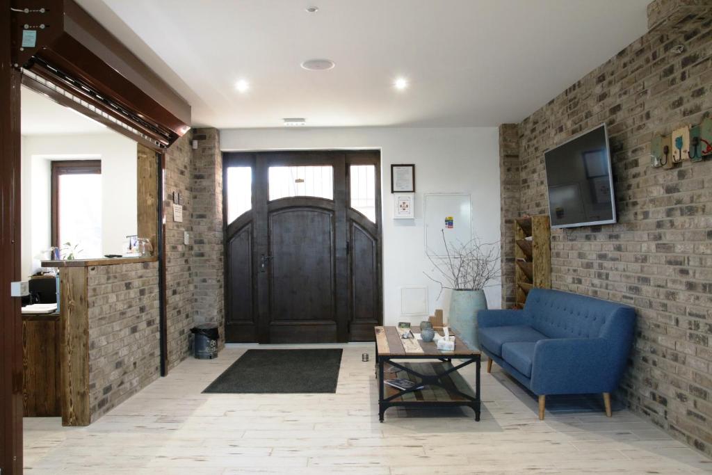 a living room with a blue couch and a brick wall at Penzión Pri Mlyne in Nitra