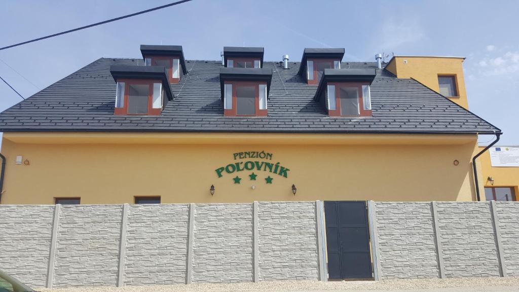 a building with a sign on the side of it at Penzión Poľovník in Moldava nad Bodvou