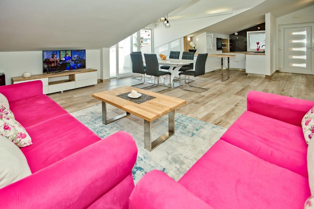 a living room with a pink couch and a table at Apartments Bubalo in Hvar