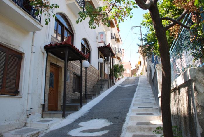 una calle vacía en un pueblo con un edificio en Hotel Bonis, en Samos