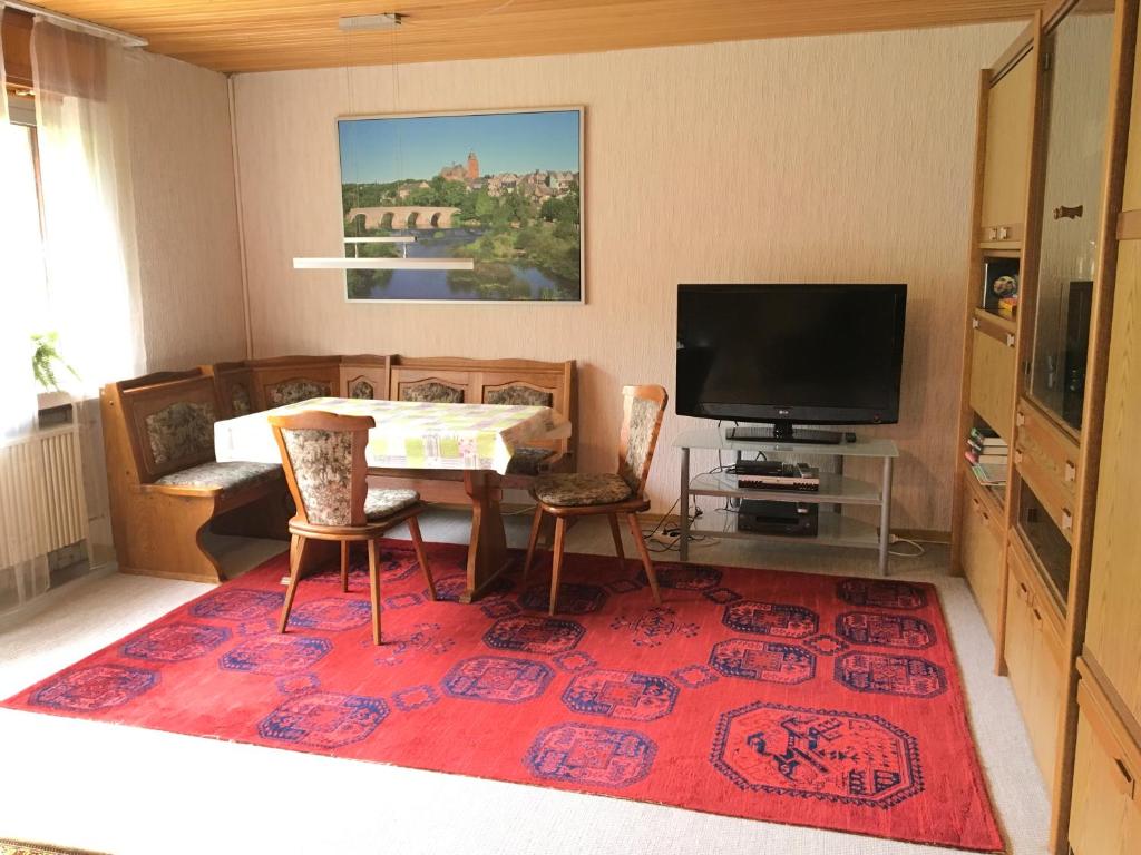uma sala de estar com uma mesa e uma televisão em Grosses Ferienhaus im Westerwald em Mengerskirchen