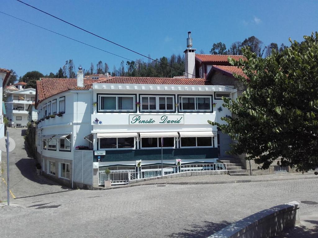 un edificio blu e bianco con un cartello sopra di Pensão David, B&B a São Pedro do Sul