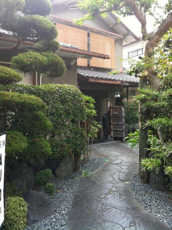 a japanese garden with a walkway in front of a building at Rakucho Ryokan in Kyoto