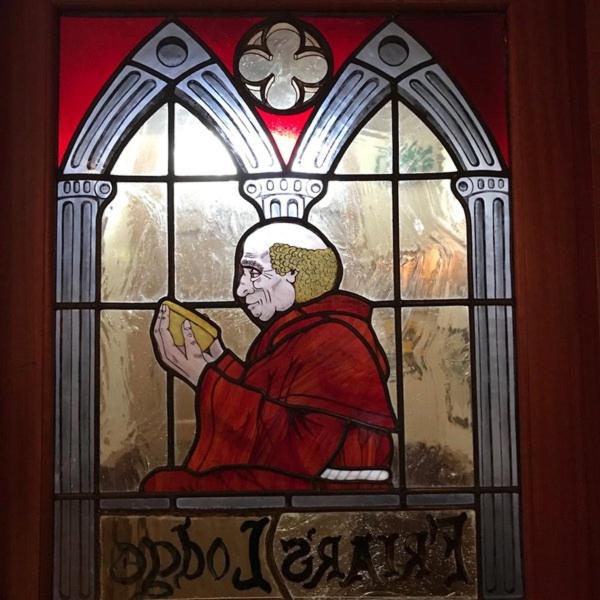 um vitral de um homem segurando um livro em Friar's Lodge em Kinsale