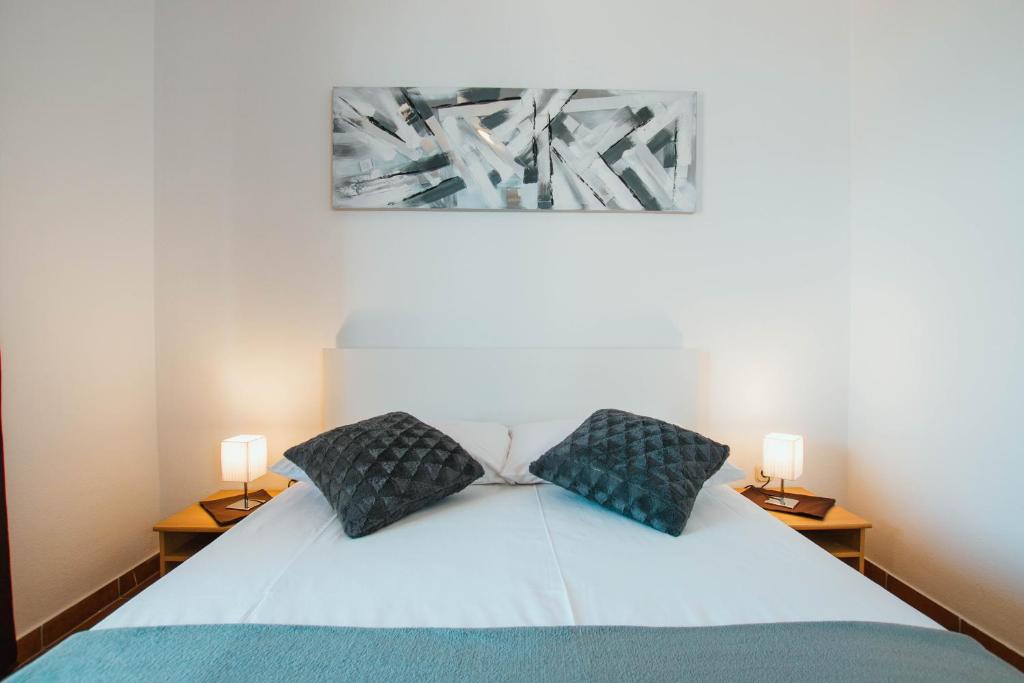 una camera da letto con un letto con due lampade sopra di Apartments Sara a Trogir