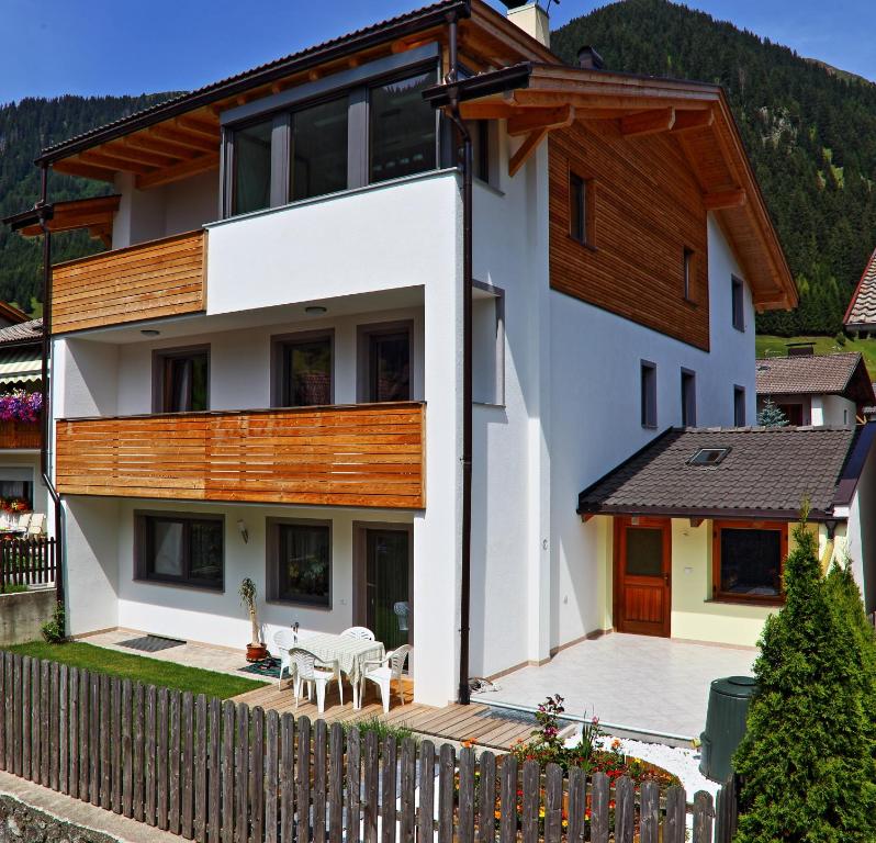 uma casa nas montanhas com uma cerca de madeira em Ferienwohnung Haus Reider em Sarentino