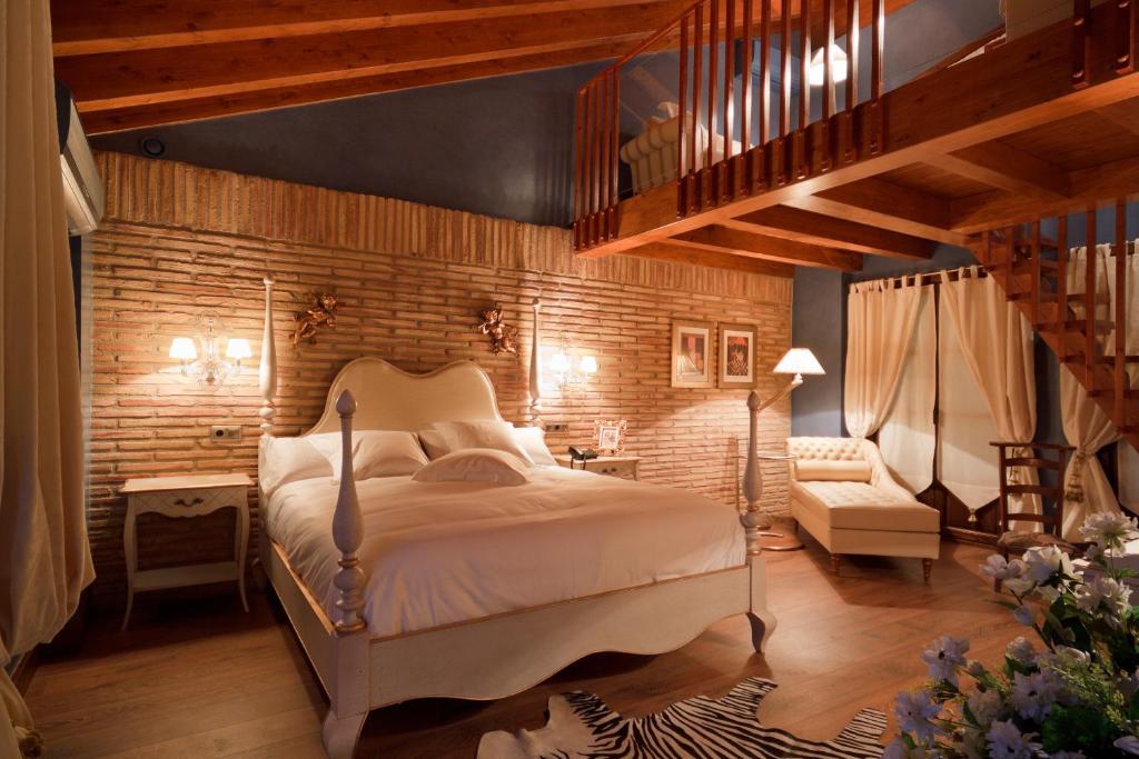 een slaapkamer met een bed en een bakstenen muur bij Hospederia de los Parajes in Laguardia
