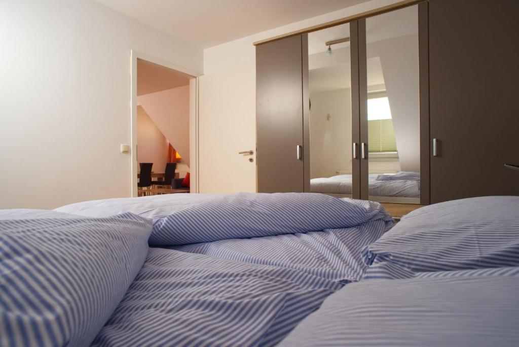 a bed with blue and white sheets in a bedroom at Pensione da Vito in Greifswald