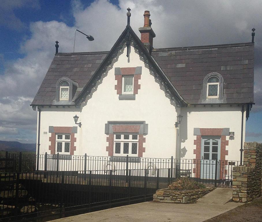 a white house with a black fence in front of it at Sea Lodge Holiday Home in Bantry