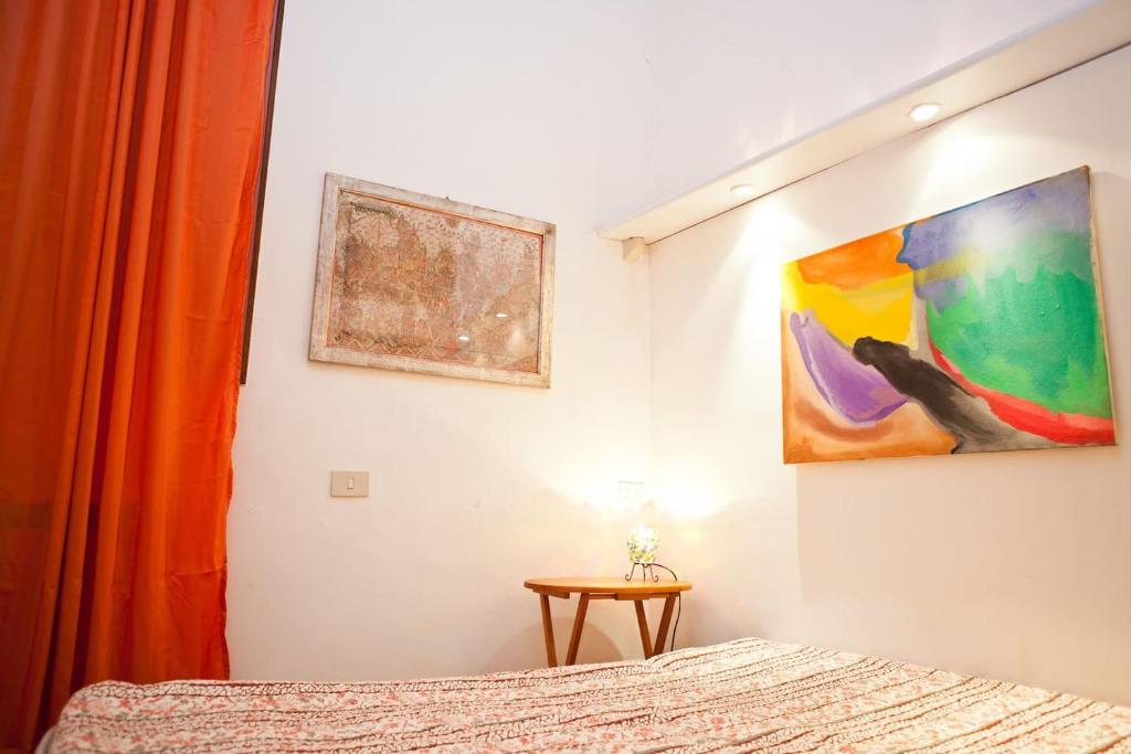 een slaapkamer met een bed en een schilderij aan de muur bij The heart of Trastevere in Rome