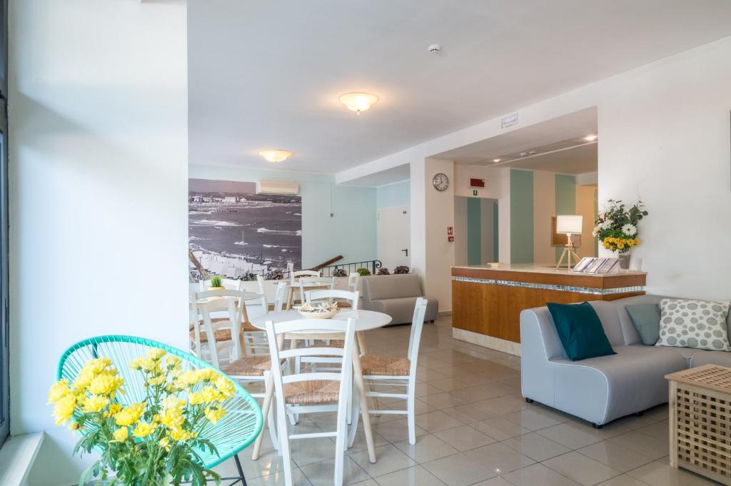 a living room with a couch and a table and chairs at Residence Baltic in Cattolica