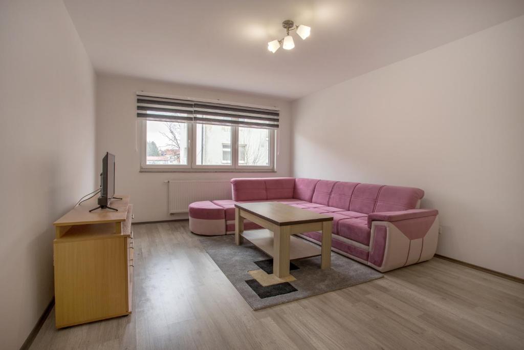 a living room with a pink couch and a table at Ivana in Tomislavgrad