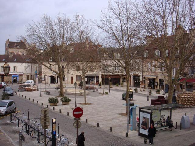 une place de la ville avec des arbres et une rue avec des bâtiments dans l'établissement Ange appart, à Dijon