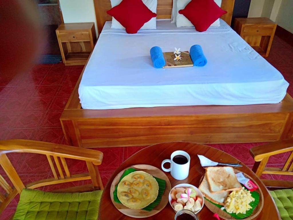 een slaapkamer met een bed en een tafel met eten erop bij Uma Kutuh Bungalow in Ubud