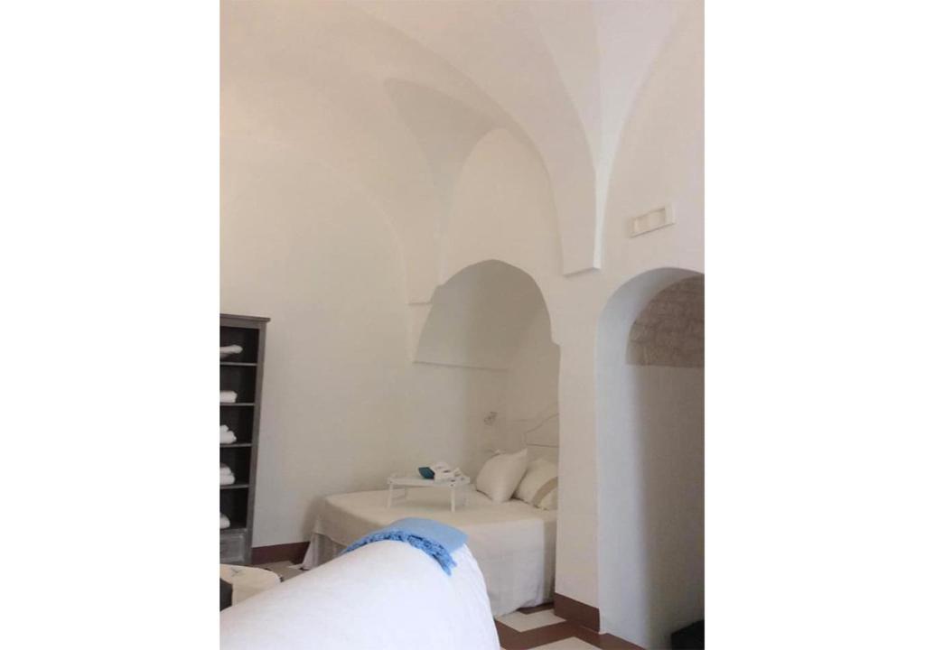 una camera da letto con pareti bianche e un letto bianco di Ostuni Piccola Dimora a Ostuni