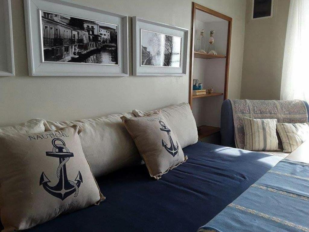 a living room with a couch with an anchor pillow at Kalymnos Beach House in Kalymnos