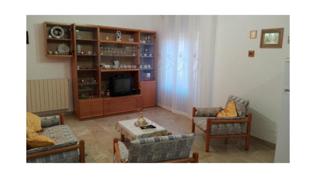 ein Wohnzimmer mit 2 Stühlen und einem TV in der Unterkunft casa Giusy in Tortorici