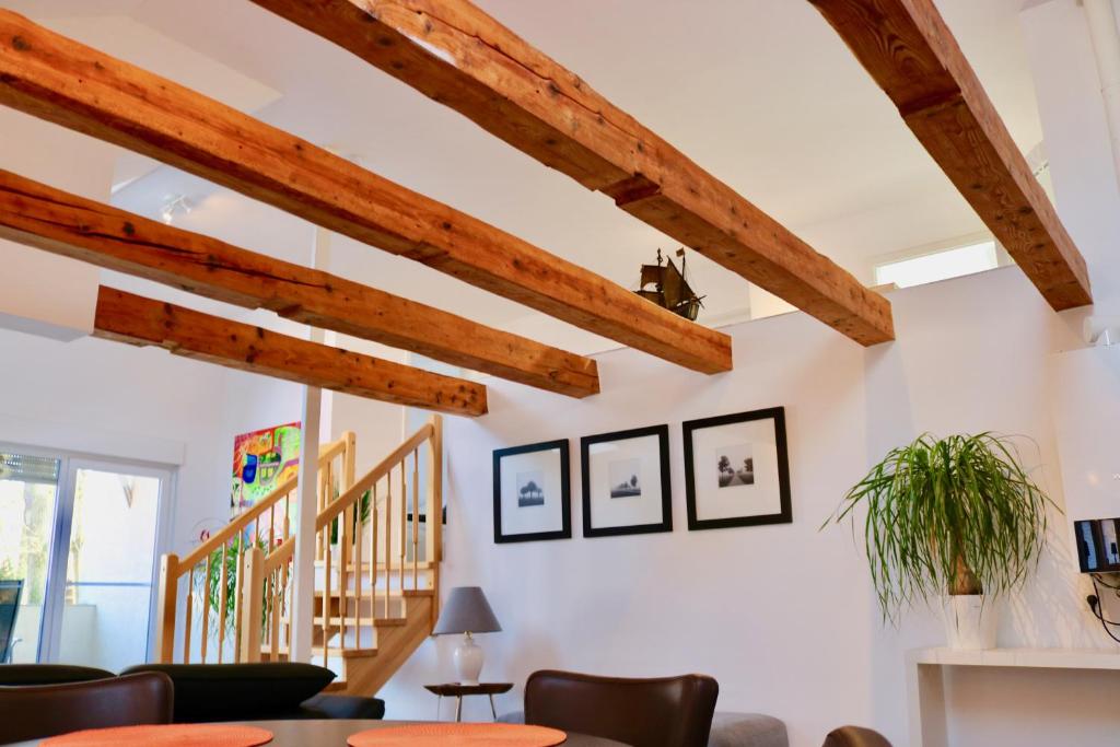 a living room with wooden ceilings and a staircase at Zwei Ferienwohnungen Anker max 5 Personen & Leuchtturm max 4 Personen, direkt in Steinhude Scheunenviertel, Balkon, WLAN , Privater Parkplatz, Wallbox in Steinhude