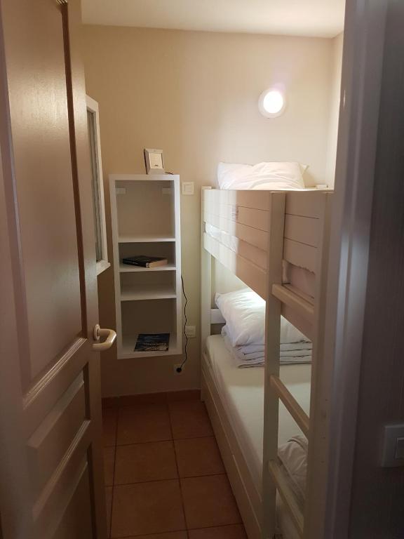 Cette petite chambre comprend des lits superposés et un placard. dans l&#39;établissement Résidence les rivages de la coudouliere, à Six-Fours-les-Plages