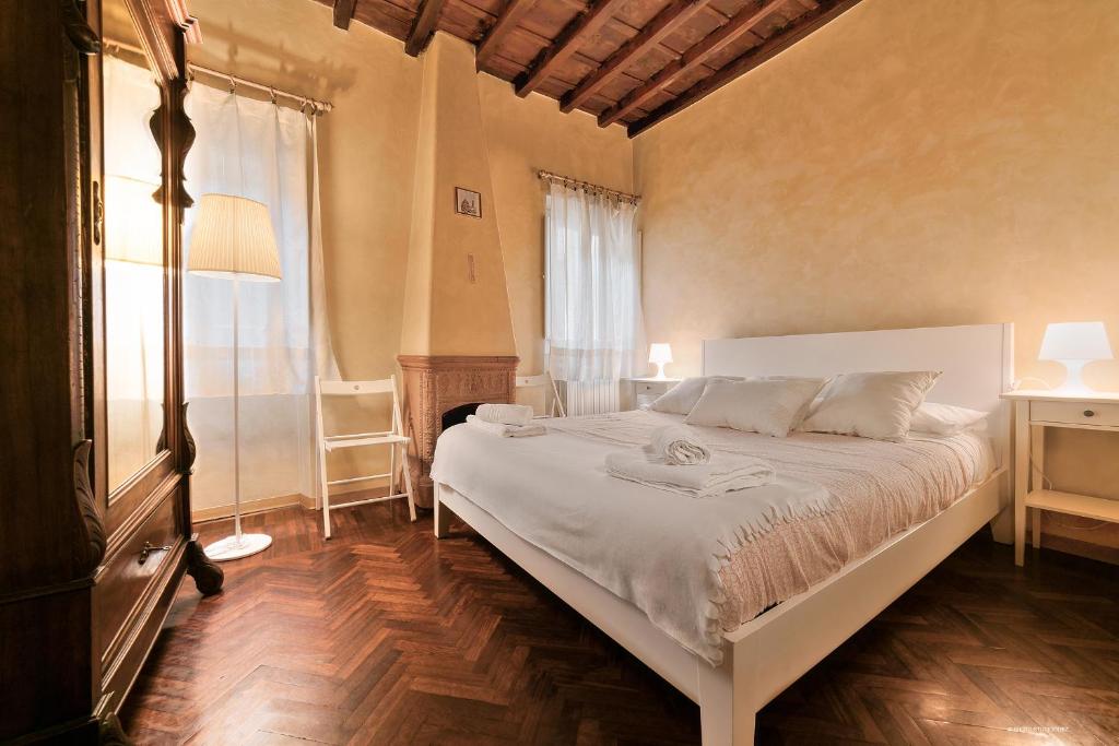 a bedroom with a white bed and a window at Wine Apartments Florence Trebbiano in Florence